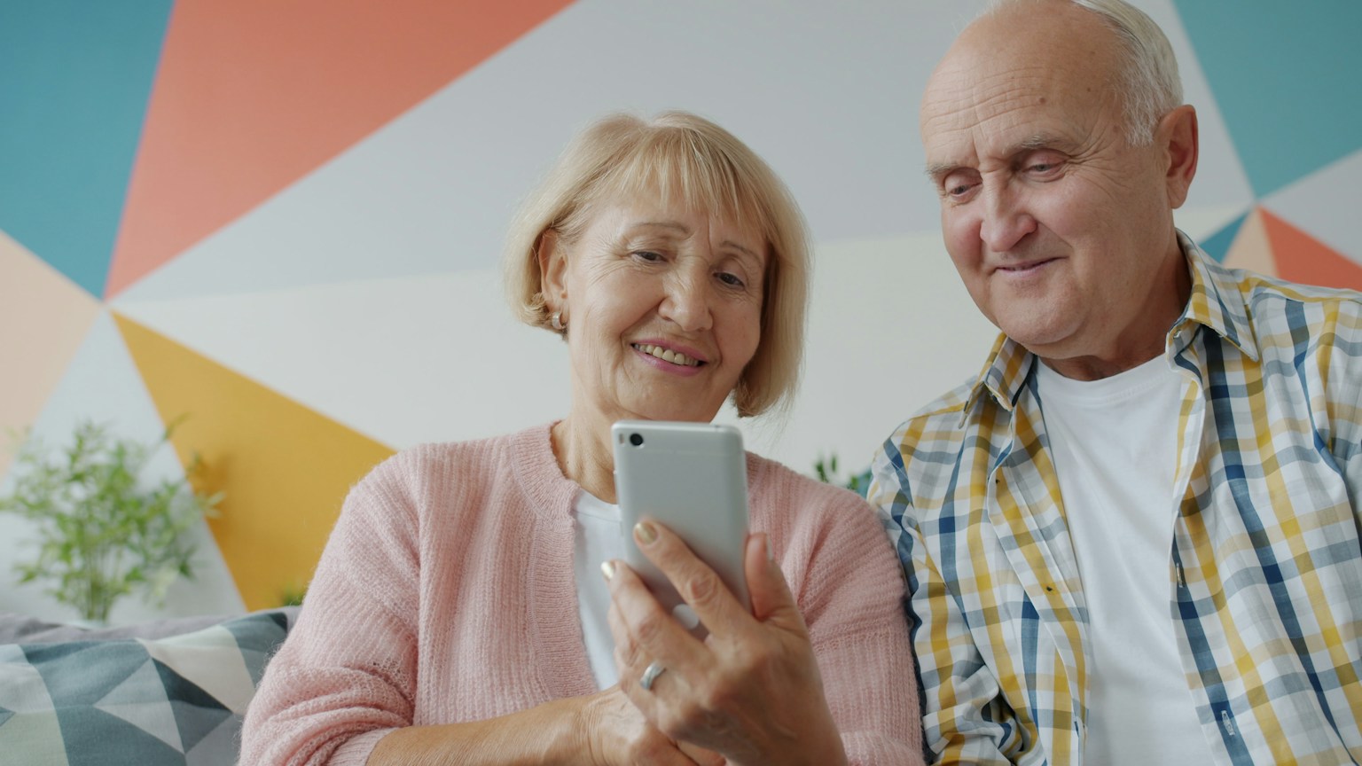 An older couple looks at a smartphone together