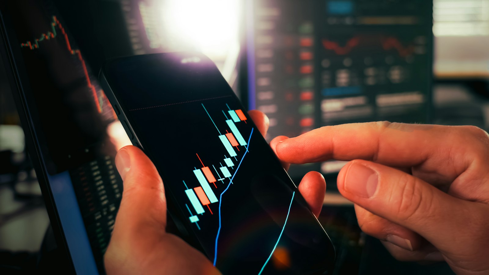 A person views investment charts on a smartphone