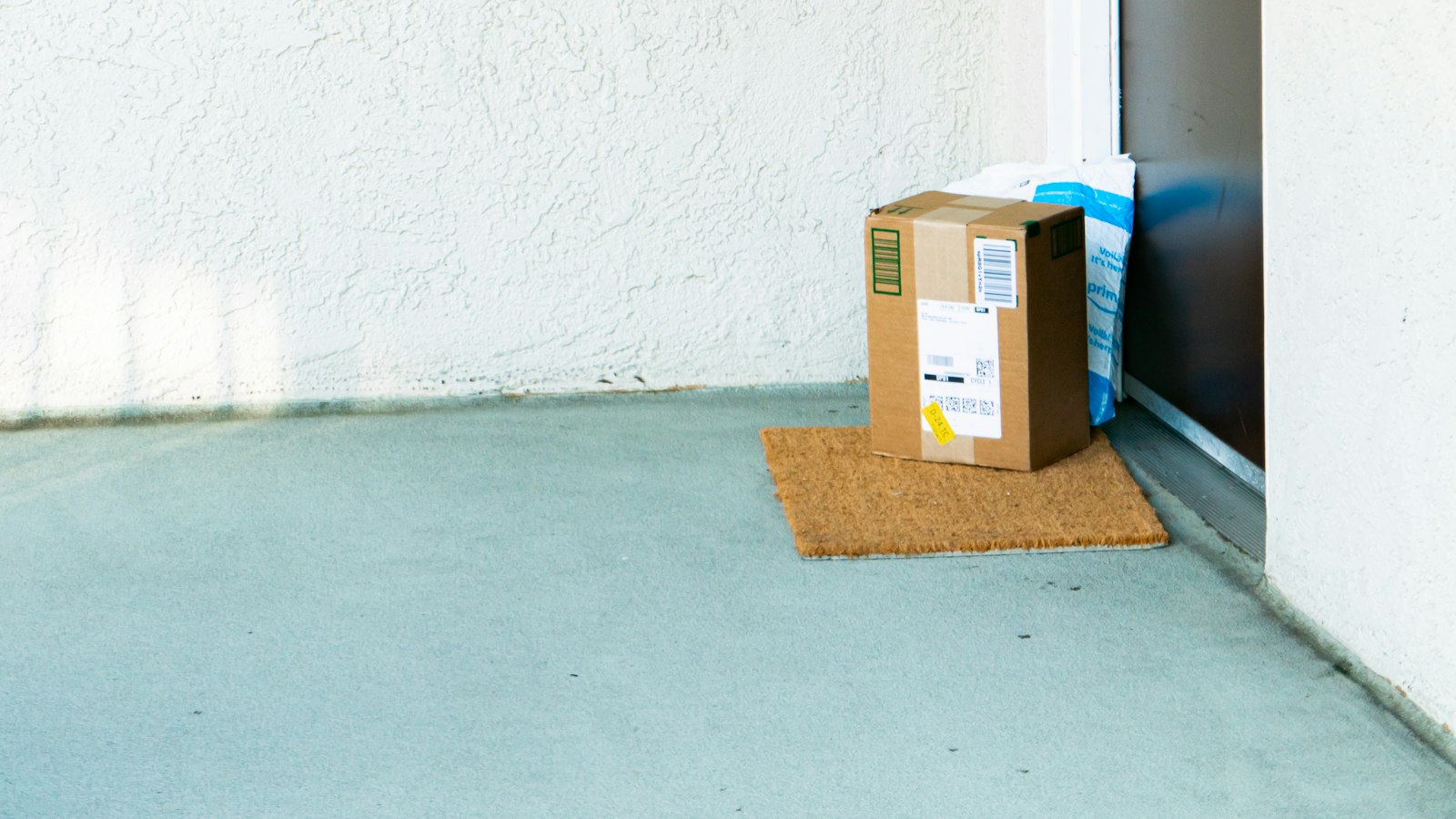 A cardboard delivery box sitting beside a front door