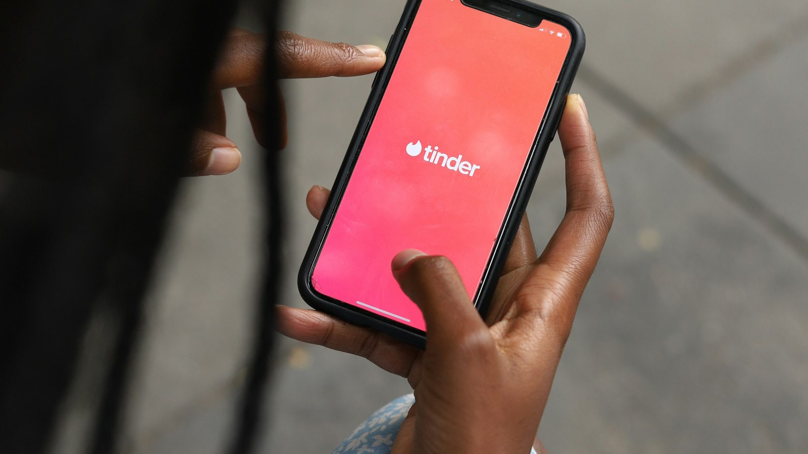 A person opens a dating app on a smartphone