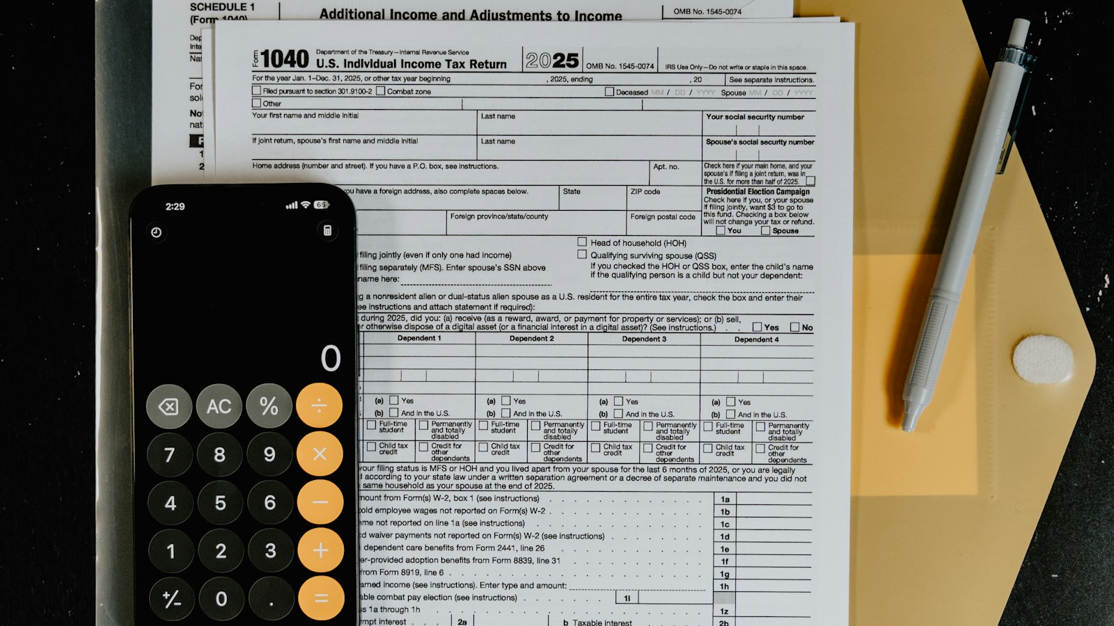 Tax forms arranged with a calculator and pen